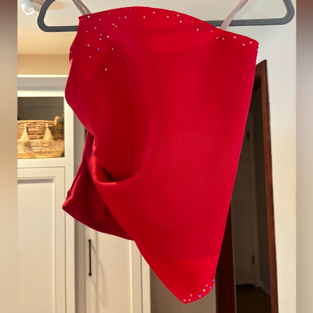 Asymmetrical red rhinestoned top and plain red shorts (worn as dance costume)